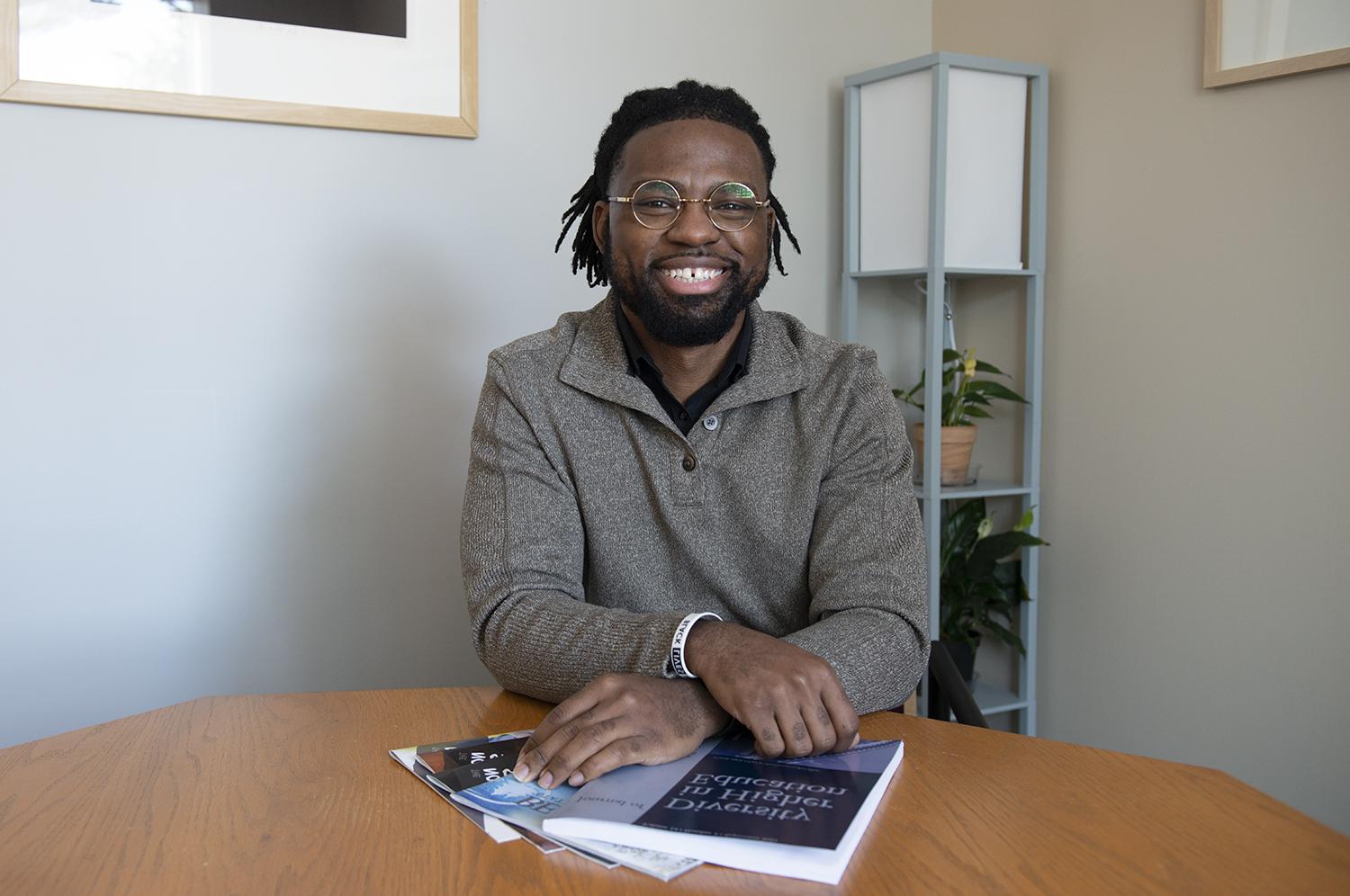 Steven Parker sitting at table holding diversity books